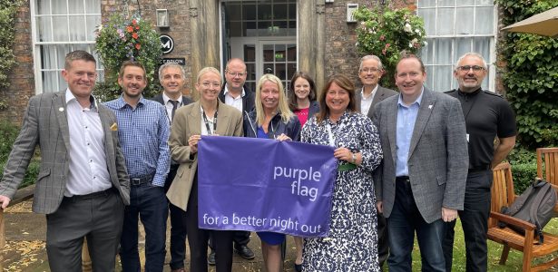 Commissioner Zoe with other members of the project hold up purple flag - for a better night out