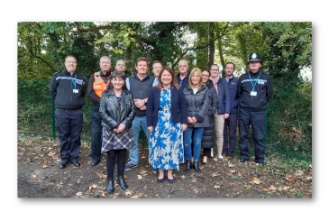Commissioner Zoe with local police, councillors and members of teh community pose for a group photo in front of the new fence.