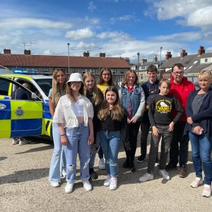 Youth commission members in front of police and fire vehicles - posing