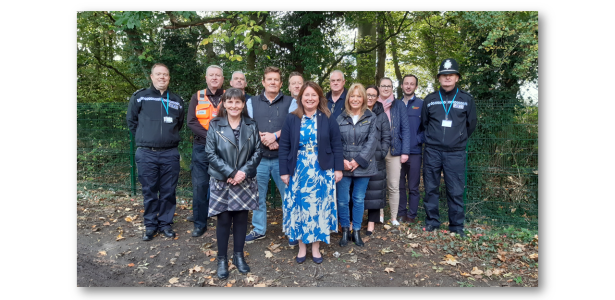 Commissioner Zoe with local police, councillors and members of teh community pose for a group photo in front of the new fence.