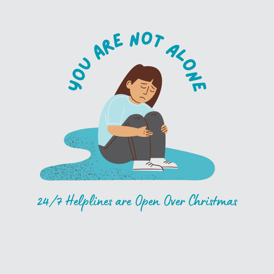 Person with a blue tshirt and grey trousers sitting down in a puddle holding their knees to their chest. The words above them read 'you are not alone' and under '24/7 Helplines are Open Over Christmas. 