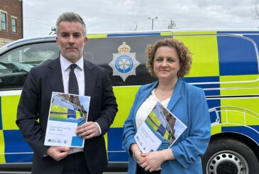 David Skaith and Jo Coles stand in front of police vehicle holding the Police and Crime plan